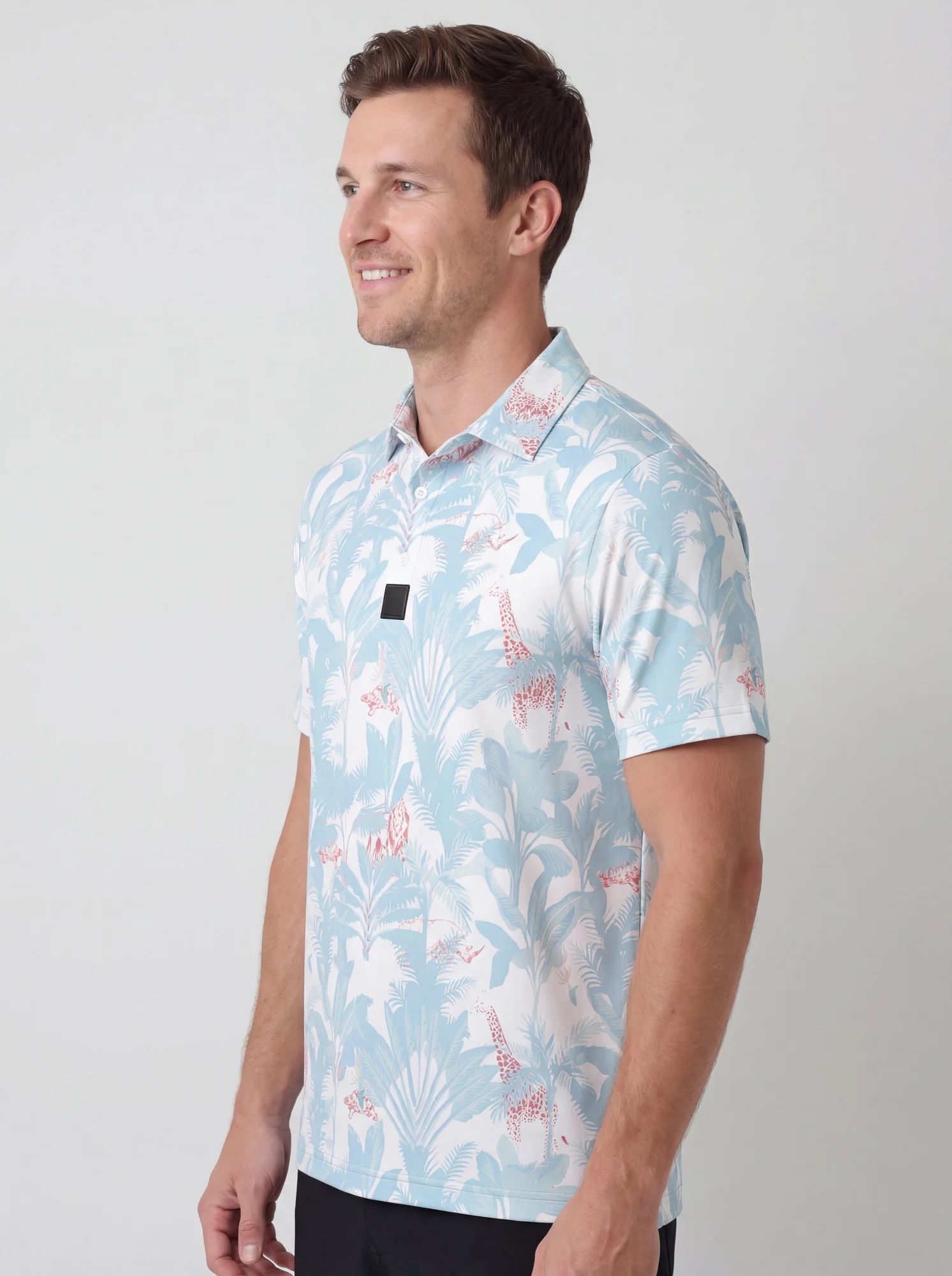 Men's powder blue tropical print polo in powder blue / white / pink, three-quarter view