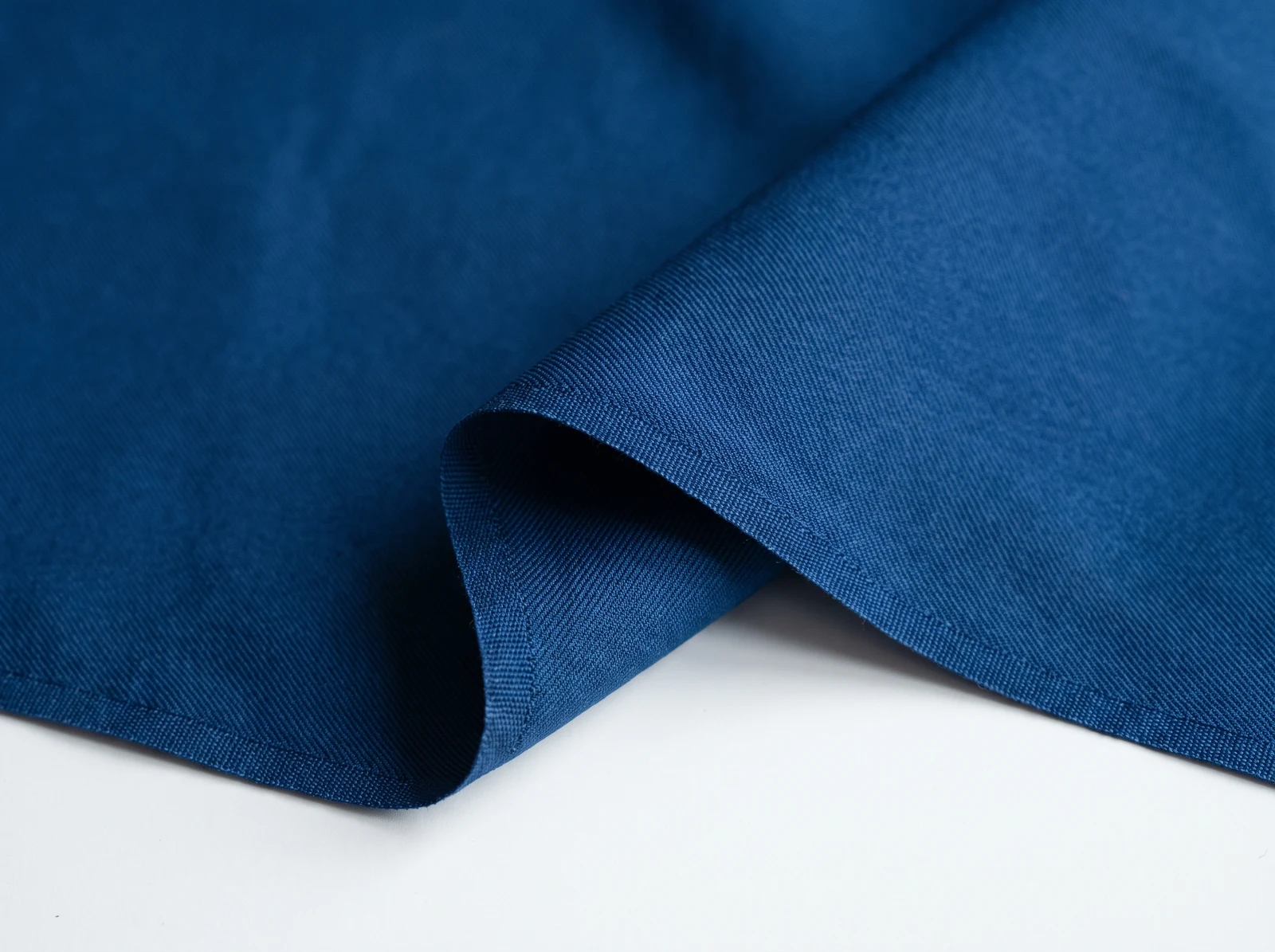 Fine navy synthetic stretch twill showing its small diagonal woven structure