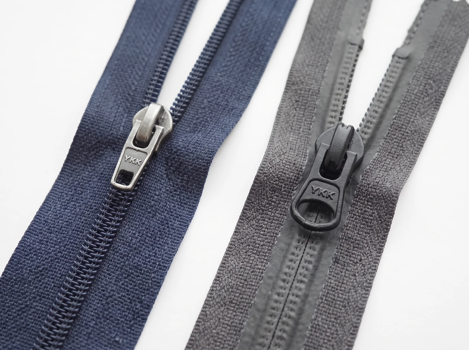 Navy and grey YKK coil zipper samples with branded sliders and pullers